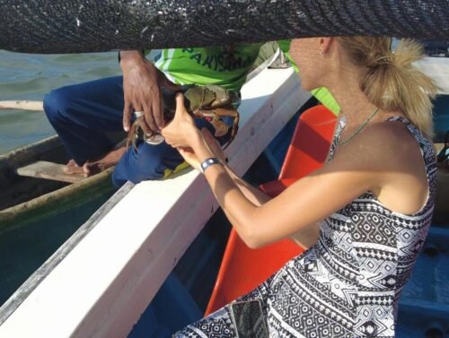 tourist enjoying lagoon tour while local lagoon fisherman