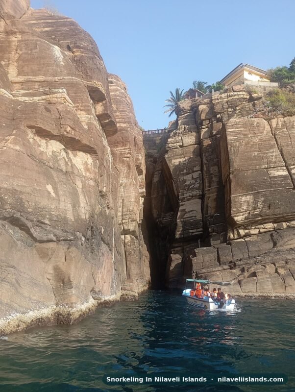 Pigeon Island snorkeling tour boat entering the narrow chasm between rock cliffs